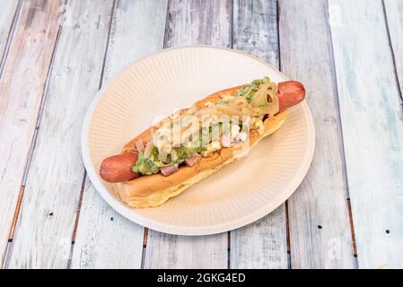 Hot Dog mit Avocado, Zwiebeln, Schinken und gekochtem Ei auf Pappteller Stockfoto