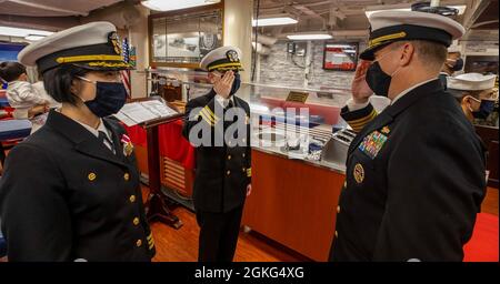 KOMMANDANT, FLOTTENAKTIVITÄTEN YOKOSUKA, Japan (14. April 2021) - Capt. Chase Sergeant (rechts), Commodore von Destroyer Squadron 15, überträgt das Kommando des Arleigh Burke-Klasse Lenkraketen-Zerstörers USS Curtis Wilbur (DDG 54) von Cmdr. Diane Cua bis Cmdr. Anthony Massey während einer Befehlswechselzeremonie. Massey übernahm das Kommando über Curtis Wilbur und entlasten Cua für zukünftige Marinestreiteinsätze. Curtis Wilbur ist der Task Force 71/Destroyer Squadron (DESRON) 15 zugeordnet, der größten vorwärtseingesetzten DESRON der Marine und der wichtigsten Surface Force der US-Flotte der 7. Flotte. Stockfoto