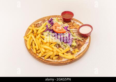 Türkische Lahmacun-Pizza mit purpurfarbenem Kohl, Eisbergsalat, Tomaten und Lamm-Pommes frites. Stockfoto