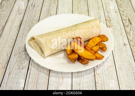 Gefüllter Weizenteig-Lahmacun wird in einem europäischen Kebab-Restaurant mit luxuriösen Pommes Frites serviert Stockfoto