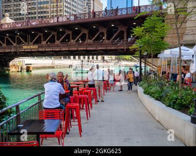 Menschen, die den Chicago Riverwalk in der Nähe der DuSable Bridge und der Michigan Avenue genießen. Stockfoto