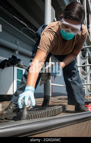 210414-N-MZ836-4004 ATLANTISCHER OZEAN (14. April 2021) Gunners Mate 2nd Class Chloe Cardona bringt auf dem amphibischen Sturmschiff USS Kearsarge (LHD 3) der Wasp-Klasse am 14. April 2021 ein Spritzschmiermittel auf das Fass eines Mark 38 25 mm-Maschinengewehrsystems. Kearsarge, Homeported in Naval Station Norfolk, ist im Gange, um für den Einsatz auf See zu zertifizieren. Stockfoto