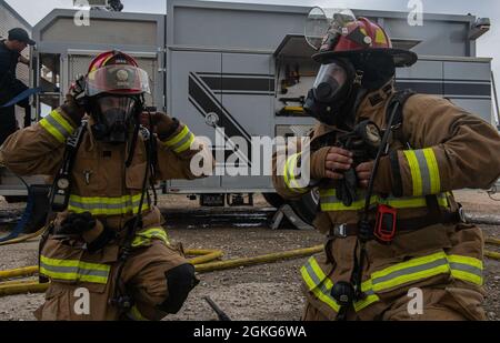 U. S. Air Force Staff Sgt. David Smith, links, und Andrew Sanchez, rechts, Joint Base San Antonio 902nd Civil Engineer Squadron Lead Firefighters, bereiten sich während einer Feuerübung am 14. April 2021 in der Joint Base San Antonio-Randolph, Texas, auf ein Szenario mit Zwangseintritt vor. Die Trainingsteilnehmer durchliefen verschiedene Live-Feuerübungen und übten unterschiedliche Antworten auf jede Übung. Stockfoto