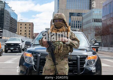 Ein Mitglied der Minnesota National Guard steht Wache mit der Minneapolis Police Department, 15. April 2021, als Teil des Operation Safety Net, Die öffentlichen Sicherheitsbemühungen, Leben und Eigentum zu schützen und das Recht für Menschen zu gewährleisten, während des Prozesses gegen den ehemaligen Minneapolis-Polizeibeamten Derek Chauvin friedlich zu protestieren. Mehr als 3,000 Minnesota Guardsmen sind im Dienst, um die Sicherheit und die Sicherheit der lokalen Gemeinschaft zu gewährleisten. Stockfoto