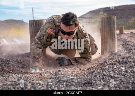 US Army Reserve Soldat SPC. Luis Rodriguez von der 820. Signal Company (TIN), kriecht durch das Low Crawl Event während eines Events für den 2021 Army Reserve Best Warrior Competition am 14. April 2021 in Mesa, Arizona. Der 335. SC(T) BWC ist ein körperlich und geistig anspruchsvolles Ereignis, das nichtbeauftragte Offiziere (NCO) und Soldaten aus dem gesamten Kommando zusammenbringt, um um den Titel des besten Kriegers zu bestreiten. Der oberste NCO und Soldat wird später in diesem Jahr zum US Army Reserve Command Wettbewerb. Stockfoto