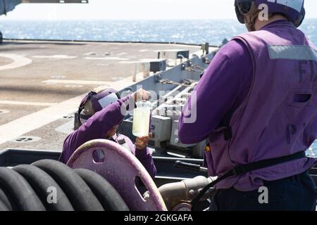 210415-N-WQ732-1017 ARABIAN GULF (15. April 2021) Maschinist für die Gasturbinensystemtechnik der 3. Klasse Madelyn Baltazar überprüft die Kraftstoffqualität auf dem Flugdeck des Lenkrakenkreuzers USS Monterey (CG 61), während er am 15. April Einsätze im Arabischen Golf durchführte. Monterey unterstützt die IKE Carrier Strike Group, während sie im 5. Flottengebiet der USA eingesetzt wird und Marinestützpunkte durchführt, um die maritime Stabilität und Sicherheit in der Zentralregion zu gewährleisten, wobei das Mittelmeer und der Pazifik durch den westlichen Indischen Ozean und drei strategische Engpässe miteinander verbunden werden. Stockfoto