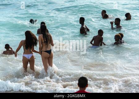 Salvador, Bahia, Brasilien - 08. Januar 2019: Menschen am Strand von Porto da Barra treten in das Meer der intensiven Wellen ein. Stockfoto