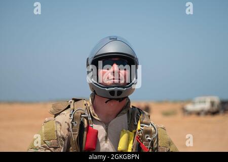 Ein Mitarbeiter der US-Luftwaffe, der dem 82. Expeditionary Rescue Squadron zugewiesen wurde, landet während eines Sprungtrainings in Dschibuti, 15. April 2021. Der 82. ERQS schließt ein Sprungtraining ab, um die Kenntnisse über alternative Einfügungsmöglichkeiten während der Rettungseinsätze und Bergemissionen des Personals zu erhalten. Stockfoto