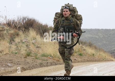 Soldaten des 807. Medizinischen Kommandos (Einsatzunterstützung) und des 76. Operational Response Command treten beim Wettbewerb der besten Krieger des Joint Command in Camp Williams vom 13. Bis 17. April 2021 an. Spc. Spencer Kasper legt ein zermürbendes Tempo während des 12 Meilen langen Ruck märz-Teils des Wettbewerbs fest. Stockfoto