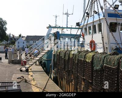 Gangplank, Fischernetze und ein Trawler vertäuten am Ufer des Kaimers im Hafen von Kirkcudbright im Südwesten Schottlands. Stockfoto