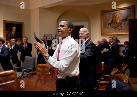 Präsident Barack Obama, Vizepräsident Joe Biden und leitende Angestellte reagieren im Roosevelt-Raum des Weißen Hauses, als das Parlament das Gesetz zur Gesundheitsreform vom 21. März 2010 verabschiedet. (Offizielles Foto des Weißen Hauses von Pete Souza) Dieses offizielle Foto des Weißen Hauses wird nur zur Veröffentlichung durch Nachrichtenorganisationen und/oder zum persönlichen Druck durch die Betreffzeile(en) des Fotos zur Verfügung gestellt. Das Foto darf in keiner Weise manipuliert werden und darf nicht in kommerziellen oder politischen Materialien, Anzeigen, E-Mails, Produkten oder Werbeaktionen verwendet werden, die in irgendeiner Weise eine Genehmigung oder Billigung vorschlagen Stockfoto