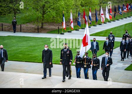 General Omar J. Jones IV. (Mittelfront), Generalkommandant, Hauptquartier der Vereinten Kräfte – National Capital Region/Military District of Washington, Und der japanische Premierminister Yoshihihide Suga (Mitte hinten) nimmt an einer Zeremonie zur Verleihung der Ehrenurne der Streitkräfte im Grab des unbekannten Soldaten auf dem Nationalfriedhof von Arlington, Arlington, Virginia, am 16. April 2021 Teil. Stockfoto