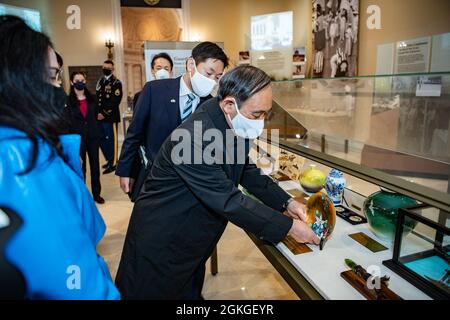 Der japanische Premierminister Yoshihihide Suga (Mitte) übergibt dem unbekannten Soldaten ein Geschenk in einer Vitrine im Memorial Amphitheatre Display Room auf dem Arlington National Cemetery, Arlington, Virginia, 16. April 2021. Zuvor nahm Suga an einer Wrath-Laying-Veranstaltung der Streitkräfte am Grab des unbekannten Soldaten Teil, die vom US-Armeemajor Omar J. Jones IV., kommandierender General, Hauptquartier der gemeinsamen Streitkräfte – National Capital Region/Military District of Washington, veranstaltet wurde. Stockfoto