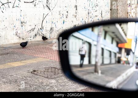 Salvador, Bahia, Brasilien - 17. Juni 2021: Blick auf die urbane Szene durch das Rückfahrglas des Autos. Stockfoto