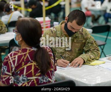 MANGILAO, Guam (16. April 2021) – SPC. Julio Rosales, ein Kampfmediziner, der der 25. Infanterie-Abteilung zugewiesen ist, überprüft die Patienteninformationen, bevor er einen COVID-19-Impfstoff verabreicht, um das COVID-19-Impfteam des Gesundheitsministeriums von Guam (DPHSS) in einer Impfklinik im Field House der Universität von Guam Calvo zu unterstützen. Das US-amerikanische Indo-Pacific Command über die US Army Pacific ist weiterhin bestrebt, die Federal Emergency Management Agency im Rahmen der Reaktion der gesamten Regierung auf COVID-19 weiterhin flexibel zu unterstützen. Stockfoto