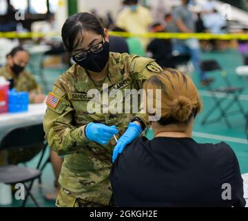 MANGILAO, Guam (16. April 2021) – Sgt. Diana Sandoval, eine Kampfmedizinerin, die der 25. Infanteriedivision zugewiesen ist, verabreicht einen COVID-19-Impfstoff zur Unterstützung des COVID-19-Impfteams des Gesundheitsministeriums von Guam in einer Impfklinik im Field House der Universität von Guam Calvo. Das US-amerikanische Indo-Pacific Command über die US Army Pacific ist weiterhin bestrebt, die Federal Emergency Management Agency im Rahmen der Reaktion der gesamten Regierung auf COVID-19 weiterhin flexibel zu unterstützen. Stockfoto