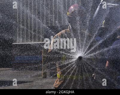 Pvt. Benjamin Szulgit demonstriert die missbräuchliche Art und Weise, Brände zu löschen, indem er die Düsenkontrolle während der Feuerwehrausbildung des Wasserfahrers am 16. April auf der Joint Base Langley-Eustis auf die niedrigste Stufe manipuliert. Stockfoto