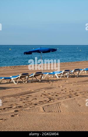 Leere Sonnenliegen am Strand in Spanien Stockfoto