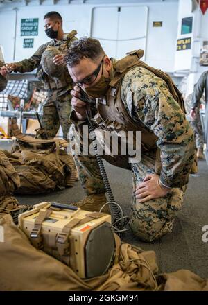 PAZIFIK (15. April 2021) U.S. Marine Corps Sgt. Kevin Schweitzer, ein nicht beauftragter Beamter für psychologische Operationen bei der 11. Marine Expeditionary Unit (MEU), führt vor einer simulierten Mission zur Verstärkung der Botschaft am 15. April eine Funktionsprüfung an einem Lautsprecher der nächsten Generation durch, der an Bord des amphibischen Sturmschiffes USS Essex (LHD 2) demontiert wurde. Marineinfanteristen und Segler der 11. MEU und der Essex Amphibious Ready Group (ARG) sind im Gange, um vor der Küste Südkaliforniens ein integriertes Training durchzuführen. Stockfoto