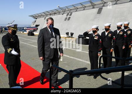 210417-N-YS140-075 Oakland, Kalifornien (17. April 2021) der amtierende Navy-Sekretär Thomas W. Harker wird von Cmdr begrüßt. Francisco Garza, Kommandant der USS Oakland (LCS 24) während der Inbetriebnahmezeremonie des Schiffes. Die LCS ist eine schnelle, agile, missionskorreierte Plattform, die für den Einsatz in Küstenumgebungen entwickelt wurde und gleichzeitig für Open-Ocean-Tasking geeignet ist. Die LCS kann die Vorwärtspräsenz, die Sicherheit im Seeverkehr, die Seekontrolle und die Abschreckung unterstützen. Oakland wird nach San Diego gebracht. Stockfoto