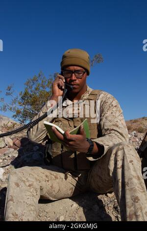 Marine Corps Lance Cpl. Jerome Robinson, ein Übertragungsnetzbetreiber, führt zusammen mit Bravo Company, 1. Bataillon, 5. Marine-Regiment einen Funkcheck während des Regimental Air Assault Course (RegAAC) durch, einem Unterevent der integrierten Trainingsübung (ITX) 3-21 im Marine Corps Air Ground Combat Center, Twentynine Palms, Kalifornien, 17. April 2021. Das Ziel von ITX ist es, eine herausfordernde, realistische Trainingsumgebung zu schaffen, die kampfbereite Kräfte hervorbringt, die als integrierte Marine Air Ground Task Force arbeiten können. Stockfoto