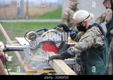 Pfc. Allison Perozzi, eine Kampfingenieurin der Bravo Company, dem 152. Brigade-Ingenieur-Bataillon der New Yorker Armee-Nationalgarde, schneidet am 16. April während einer kollektiven Trainingsexterzise der Heimatschutztruppe in East Amherst, New York, Holzgerüste. Perozzi und ihre Einheit sind Teil des Such- und Extraktionselements der FEMA Region II Homeland Response Force. Stockfoto