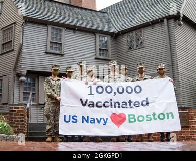 Seeleute der US-Marine, die dem Naval Medical Center Portsmouth, dem Navy Cargo Handling Bataillon 1 und der Navy Expedition Logistics Support Group zugewiesen wurden, halten vor dem Paul Revere House in Boston ein Banner hoch, um die Verabreichung von 100,000 COVID-19-Impfungen zu feiern, 17. April 2021. US-Dienstmitglieder aus dem ganzen Land werden zur Unterstützung der Maßnahmen des Verteidigungsministeriums zur Reaktion auf Impfstoffe eingesetzt. Das U.S. Northern Command über die U.S. Army North ist weiterhin bestrebt, die Federal Emergency Management Agency im Rahmen des w-ten Verteidigungsministeriums weiterhin flexibel und flexibel zu unterstützen Stockfoto