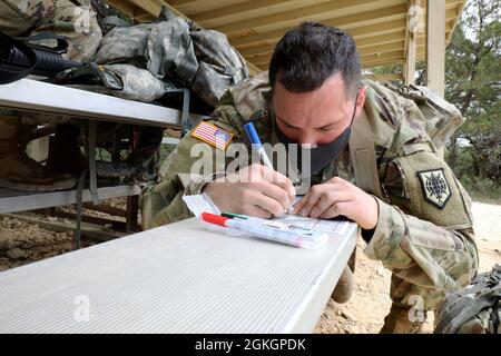 Personal Sgt. Myles Kalf, 323. Militärgeheimdienst-Bataillon, zeichnet Kartenpunkte während der Landnavigation des Military Intelligence Readiness Command (MIRC) Best Warrior Competition (BWC) auf der Joint Base San Antonio – Camp Bullis am 17. April 2021 auf. Die besten Soldaten aus dem MIRC konkurrieren jährlich im BWC um den Titel des besten Kriegers. Stockfoto