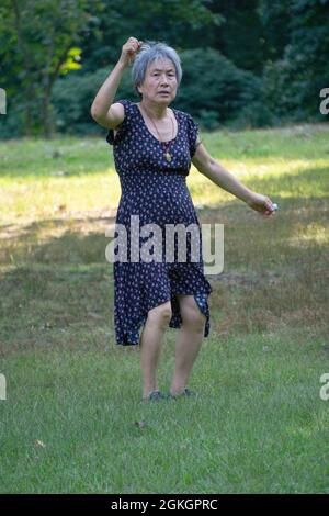 Eine ältere Frau nimmt an einem Tanzkurs in einem Park in Flushing, Queens, New York City, Teil. Stockfoto