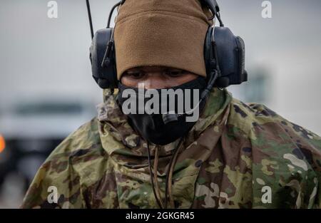 US Air Force Staff Sgt. Kendall Washington, ein Crewchef des 1. Special Operations Aircraft Maintenance Squadron, kommuniziert mit anderen Mitgliedern, die am Schleppen eines „Spooky“-Kanonenschiffs der AC-130U zum airpark in Hurlburt Field, Florida, 17. April 2021 beteiligt sind. Während das Kanonenschiff aktiv war, konnte es zwei Ziele gleichzeitig mit unterschiedlichen Stufen verfolgen und eingreifen; es ging 2020 in den Ruhestand. Stockfoto