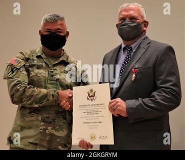 Der Oberst der US-Armee, Anthony Fournier, der Brigadekommandant des Kampfteams der 48th Infantry Brigade, Georgia Army National Guard, überreicht dem pensionierten Oberbefehlshaber 4 Eric McKee seine Ruhestandsurkunde am 18. April 2021 im Freiwilligenhauptquartier in Macon, Georgia. McKee diente über neun Jahre in der Brigade und „kehrte nach Hause“ für seine Pensionierung Zeremonie. Stockfoto