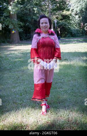 Posierte Porträt einer Frau in der Kai Xin Yizhu Tanzgruppe. Vor einer Vorstellung in einem Park in Flushing, Queens, New york City Stockfoto