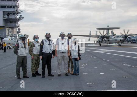 Der ehrenwerte James E. Geurts, der die Aufgaben des (PTDO) Untersekretär der Marine, Mitte rechts, Frau Alaleh Jenkins, PTDO Assistant Secretary of the Navy, Financial Management and Comptroller, rechts, und Royal Canadian Navy Rear ADM erfüllt. Steve Waddell, Vice Commander Seonder Fleet, Mitte links, Pause für ein Gruppenfoto auf dem Flugdeck der USS Gerald R. Ford (CVN 78) während eines Schiffsbesuchs am 18. April 2021. Während des Besuchs trafen sich die Beamten mit dem Kommandanten der Carrier Strike Group (CSG) 12 und anderen Befehlshabern der Kriegsführung, um einen detaillierten Einblick in die laufenden Operationen und wichtige Meilensteine zu erhalten Stockfoto