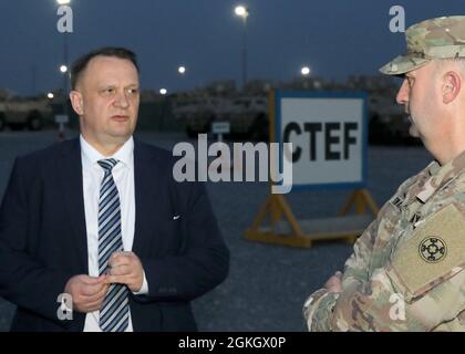 Der polnische Botschafter in Kuwait, Pawel Lechowicz, spricht am 19. April 2021 im Lager Arifjan, Kuwait, mit der Reserve-Armee Brig. General Justin M. Swanson, stellvertretender Generalkommandant des 1. Theater Sustainment Command-Operational Command-Postens, im Hof des 1. TSC für gepanzerte Sicherheitsfahrzeuge, Humvees und andere Fahrzeuge, die für die Verteilung an irakische Sicherheitskräfte über den IS-Bekämpfung, den Trainings- und Ausrüstungsfonds oder CTEF zur Unterstützung der Operation Inhärent Resolve bestimmt sind. Derzeit werden polnische Truppen und Zivilpersonal, darunter Soldaten der Sondereinsätze und Geheimdienstanalysten, in die OIR entsandt. Stockfoto