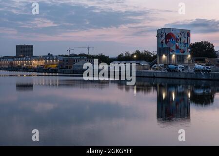 Laeken, Region Brüssel-Hauptstadt, Belgien - 09 10 2021: Wohn- und Industriegebäude, die sich während des goldenen Hous im Wasser des Kanals spiegeln Stockfoto