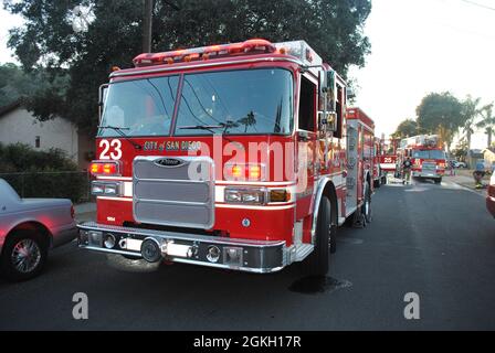 San Diego Fire Rescue Engine 23 vor dem Hintergrund eines Hausbrands Stockfoto