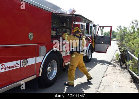 Der Feuerwehrmann aus San Diego zieht während einer Bürstenfeuerübung im Mission Trails Regional Park in Mission Gorge, San Diego, die Ausrüstung vom Motor ab. Stockfoto