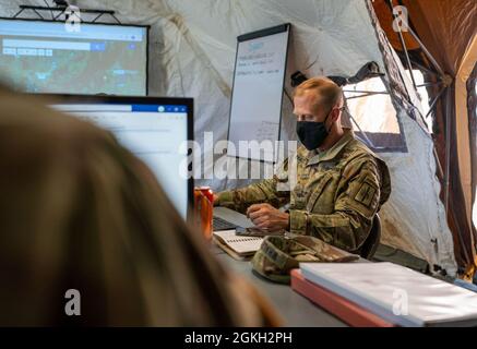 US Army Maj. Nichola Whaley, Executive Officer des 204. Ingenieurbataillons der Hauptquartiersgesellschaft, 153. Truppenkommandos, 53. Truppenkommandos, arbeitet auf seinem Laptop im Regional Support Camp Panther, North Vernon, Ind., 20. April 2021. Soldaten der Nationalgarde von NY unterstützen andere Bataillone der Nationalgarde während der Guardian Response Übung 21 in Indiana operativ und logistisch. Stockfoto