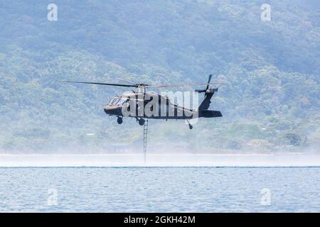 Eine US-Army-Luftbesatzung führt während des Überwassertrainings in Trujillo Bay, Honduras, am 20. April 2021 eine Höhlenleiter-Trainingsübung in einem HH-60L Blackhawk-Hubschrauber durch, der dem 1. Bataillon, dem 228. Luftfahrtregiment, Joint Task Force-Bravo, Soto Cano Air Base, Honduras, zugewiesen wurde. Die Erfahrungen aus diesem Training ermöglichen es JTF-Bravo, den Einsatz bei sich entfaltenden Krisen wie Naturkatastrophen oder Personalrettungsmissionen voranzutreiben. Stockfoto