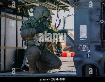 Ein dem 88. Test- und Evaluierungssquadron zugewiesener Airman führt während eines Entwicklungstests auf der Nellis Air Force Base am 20. April 2021 Vorflugkontrollen an einem HH-60G Pave Hawk-Hubschrauber in voll chemischer, biologischer, radiologischer und nuklearer Flugausrüstung durch. Airman stellte den Bewertern nach dem Test individuelle Notizen zur Verfügung, um Änderungen oder Verbesserungen vorzunehmen. Stockfoto