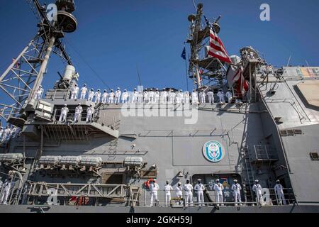 210421-N-KK394-1080 MARINESTÜTZPUNKT MAYPORT, Florida (21. April 2021) Matrosen, die dem Lenkraketen-Kreuzer USS Philippine Sea (CG 58) zugewiesen wurden, müssen die Schienen befahren, während das Schiff in die Marinestation Mayport, Fla. Einfährt. Die philippinische See kehrte von einem 10-monatigen Einsatz in die Einsatzgebiete der 2., 5. Und 6. Flotte der USA zurück. Stockfoto