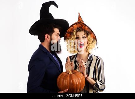 Glückliches Paar in Hexenhüten mit Kürbis. Junge Leute an Halloween gekleidet. Feiern und feiern. 31. oktober. Stockfoto