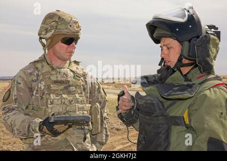 Sgt. Clayton Bradley hört auf Staff Sgt. John Olivas, beide mit dem 79. EOD Bn., 704. EOD Co. Beschreiben, wie er Sprengstoffe während des EOD Team of the Year Wettbewerbs 2021 platzieren wird. An dem Wettbewerb auf dem Pinion Canyon Maneuve Site, Colorado, nahmen zwölf der besten EOD-Teams Teil, die drei Bataillone, 11 Basen und acht Bundesstaaten repräsentierten. Stockfoto