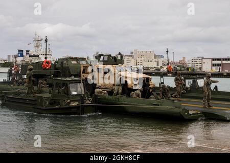 US-Marineinfanteristen mit 9. Ingenieur-Unterstützung Bataillon und Navy Seabees mit Marine Mobile Construction Bataillon 4 Montieren Sie eine verbesserte Bandbrücke mit Marines von 12th Marines, 3d Marine Division, um während der Übung ein High Mobility Artillery Rocket System zu transportieren Pacific Pioneer, Naha Port, 21. April 2021. Pacific Pioneer diente als 9. ESB Marine Corps Combat Readiness Evaluation sowie als Gelegenheit, die Fähigkeit zu demonstrieren, Expeditions-Advanced Basen mit überlebensfähigen Kraftschutz aufrechtzuerhalten, Marine-Integration zu üben und Langstreckenfeuern und taktischen Logisti zu positionieren Stockfoto