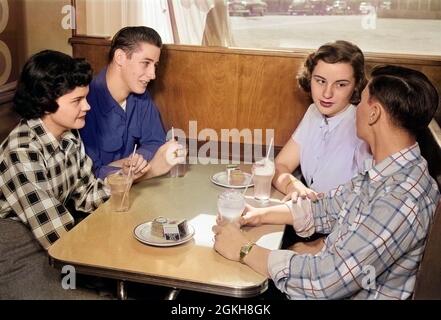 ZWEI TEENAGER-PAARE AUS DEN 1950ER JAHREN AM STAND IN EINEM DINER IN KARIERTEN UND EINFARBIGEN HEMDEN, DIE SOFTDRINKS TRINKEN UND MITEINANDER REDEN - F585C LAN001 HARS SUBURBAN SODA URBAN OLD TIME NOSTALGIE OLD FASHION 1 JUVENILE KOMMUNIKATION CHATTEN JUNGE ERWACHSENE GETRÄNKE SNACK LIFESTYLE FRAUEN CRACKER GESUNDHEIT HEIM LEBEN KOMMUNIKATION KOPIE RAUM FREUNDSCHAFT HALBE LÄNGE MÄNNER SPRECHEN TEENAGER MÄDCHEN TEENAGER JUNGE CHAT S & W TABELLEN POP DATING CAFE STAND GLÜCK FAST FOOD NÄHREN GETRÄNKE FREIZEIT MATE SNACK ESSEN MANN UND FRAU HIGH SCHOOL SOFTDRINK VERBINDUNG DOPPELT DATUM SODA BRUNNEN SODA POP NAHRUNG MALZ SHOP KOST KOMMUNIZIEREN Stockfoto