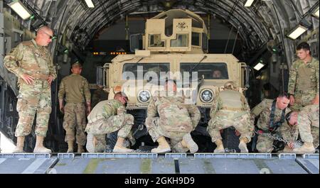 U.S. Army Command Sgt. Maj. Carlos Quick beobachtet, wie Soldaten der Task Force Iron Valor ein hochmobiles Mehrzweck-Radfahrzeug (HHMMWV) an Bord eines C-17 Globemaster III der US-Armee auf der Ali Al Salem Air Base, Kuwait, 22. April 2021, sichern. Die Validierungsübung, ein Höhepunkt, war das erste Mal, dass viele als Task Force Iron Valor zusammenarbeiteten. Stockfoto