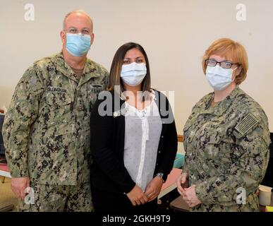 JACKSONVILLE, Florida (22. April 2021) - US Navy Surgeon General Rear ADM. Bruce Gillingham und Capt. Teresa Allen, Kommandant des Naval Hospital Jacksonville und Kommandant des Navy Medicine Readiness and Training Command Jacksonville, treffen sich am 22. April mit der Ombudsfrau Stephanie Horton an Bord des NAS Jacksonville. Stockfoto