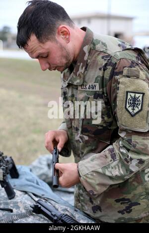 Personal Sgt. Myles Kalf, 323. Militärgeheimdienst-Bataillon, stellt während des Waffensprungs-Events des Geheimdiensts Readiness Command (MIRC) Best Warrior Competition (BWC) am 21. April 2021 auf der Joint Base San Antonio – Camp Bullis eine Trägergruppe wieder zusammen. Das Ereignis des Waffensprungs erfordert, dass die Teilnehmer einen Haufen von Waffenteilen durchsortieren und die Waffen identifizieren, zu denen sie gehören, um drei separate Waffensysteme wieder zusammenbauen zu können, bevor die Zeit abläuft. Dieses Ereignis testet das Wissen der Soldaten über Waffen und ihre Fähigkeit, unter Druck zu arbeiten. Stockfoto