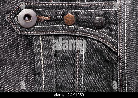 Foto im Hintergrund mit Struktur aus Denim-Jeans-Stoff mit Nähten und Metallknöpfen. Stockfoto