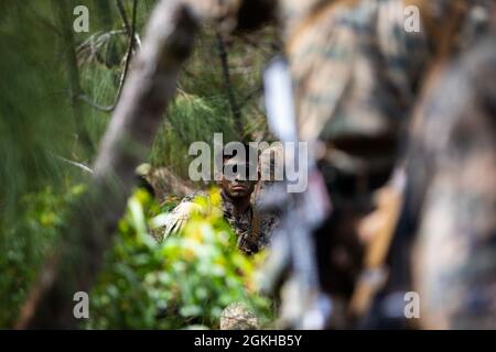 U.S. Marine Corps CPL. Luis Godoy, Teamleiter, Bravo Company, 1. Bataillon, 3d Marines, Hört sich die Anweisungen von SSgt an. Kevin Cassara, Instruktor für den Advanced Infantry Course, erläutert, wie das Abstoßen der steilen Steigung im Rahmen des Advanced Infantry Course im Kahuku Training Area, Hawaii, am 22. April 2021, durchgeführt wird. Dieser Kurs ist ein experimenteller Proof-of-Concept mit dem Ziel, die Ausbildung zu modernisieren und den Führungskräften neue Fähigkeiten zu bieten. Stockfoto